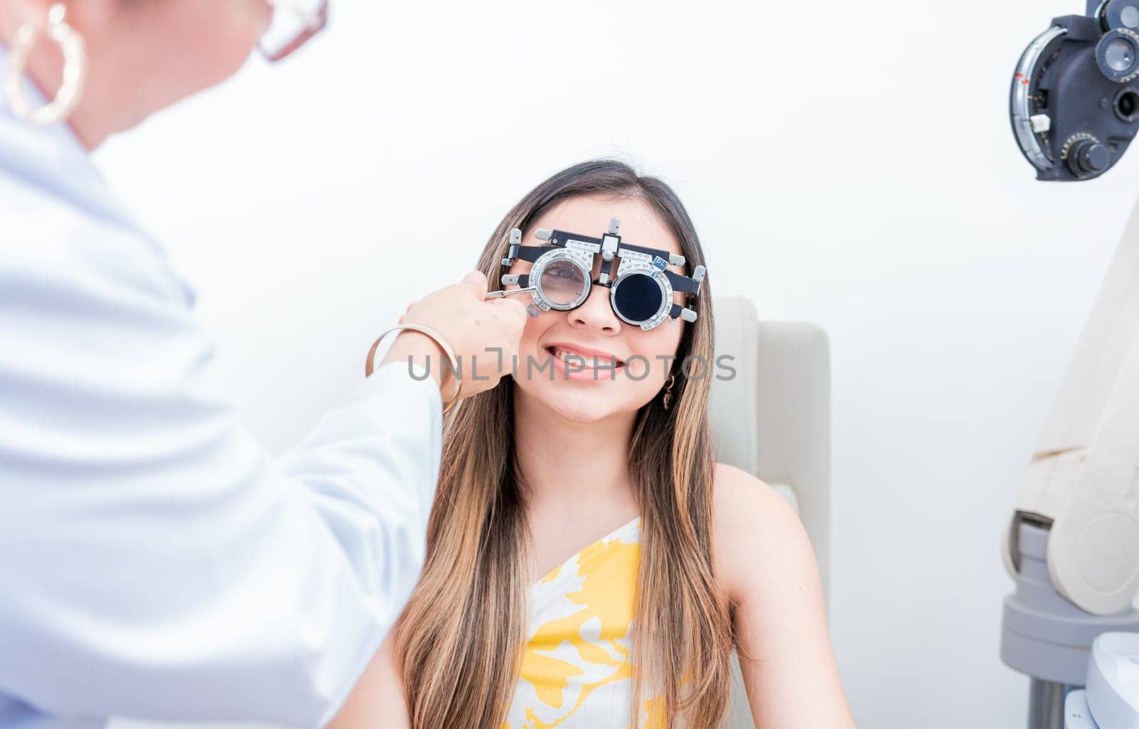 Smiling patient with optometrist trial frame. Closeup of optometrist examining patient with optometrist trial frame by isaiphoto