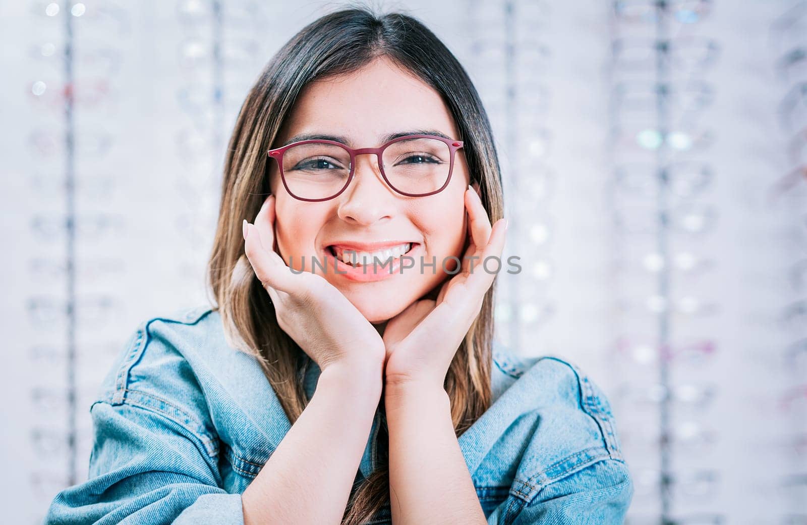 Portrait of beautiful girl modeling glasses in an optical store. Happy girl modeling glasses in an optical lens store