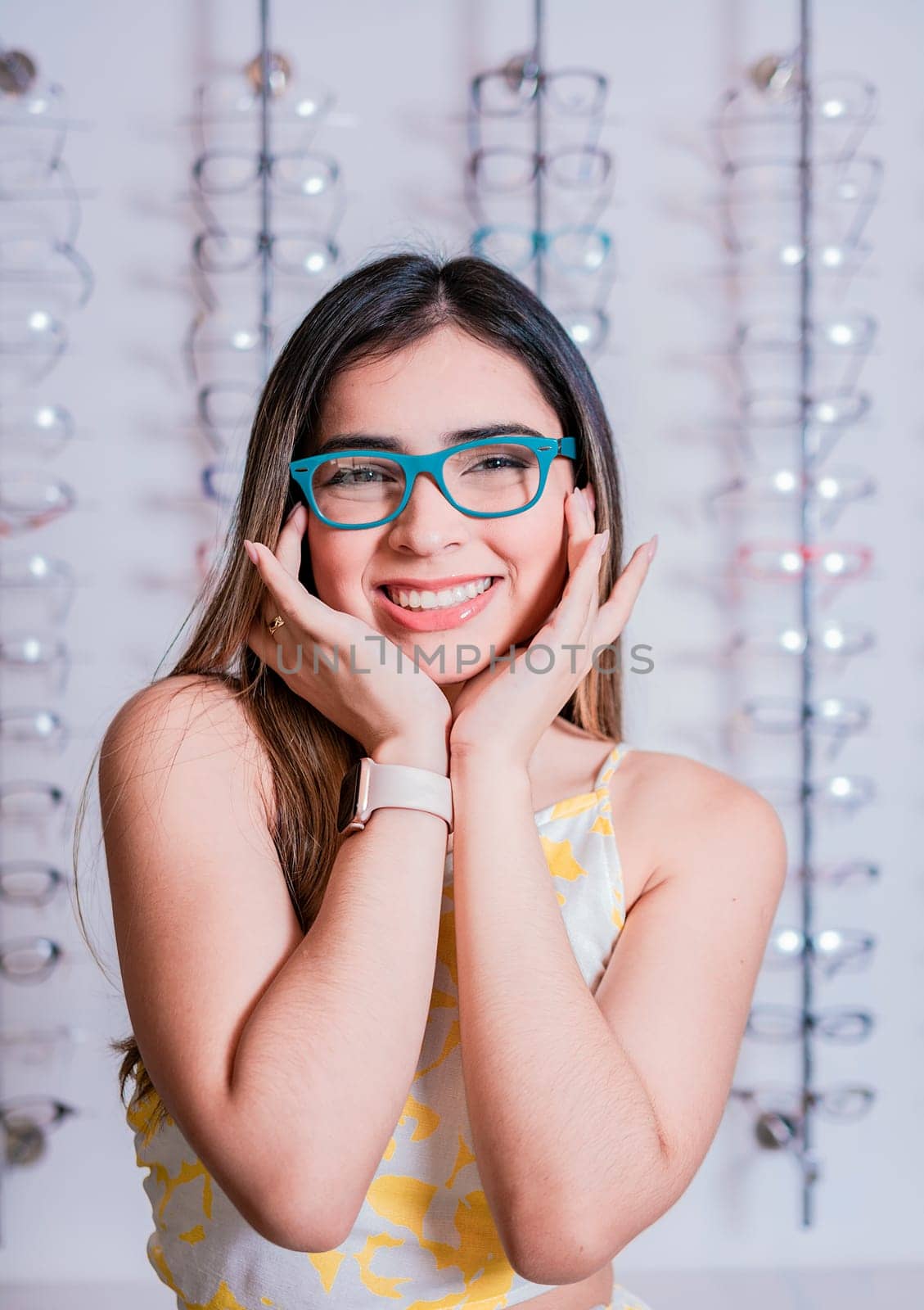 Portrait of a happy female customer wearing glasses in an eyewear store. Smiling girl wearing glasses in an eyeglass store by isaiphoto