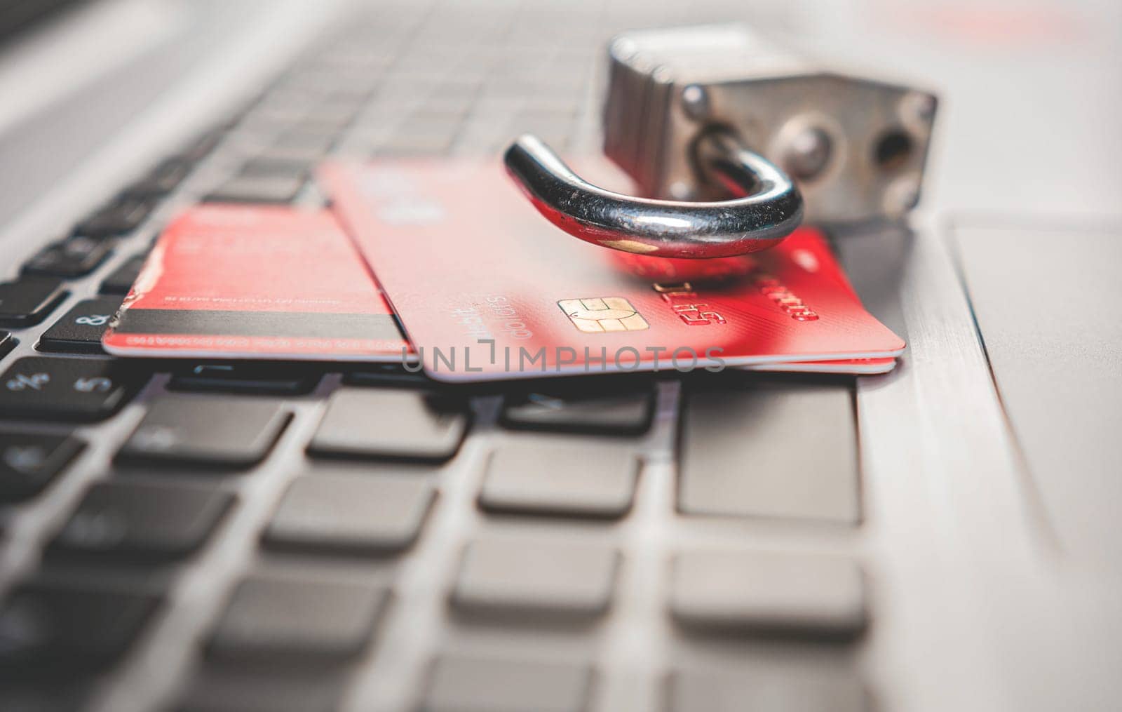 Online vulnerability concept with credit card. Credit card cyber security concept. Padlock on top of credit card on computer keyboard