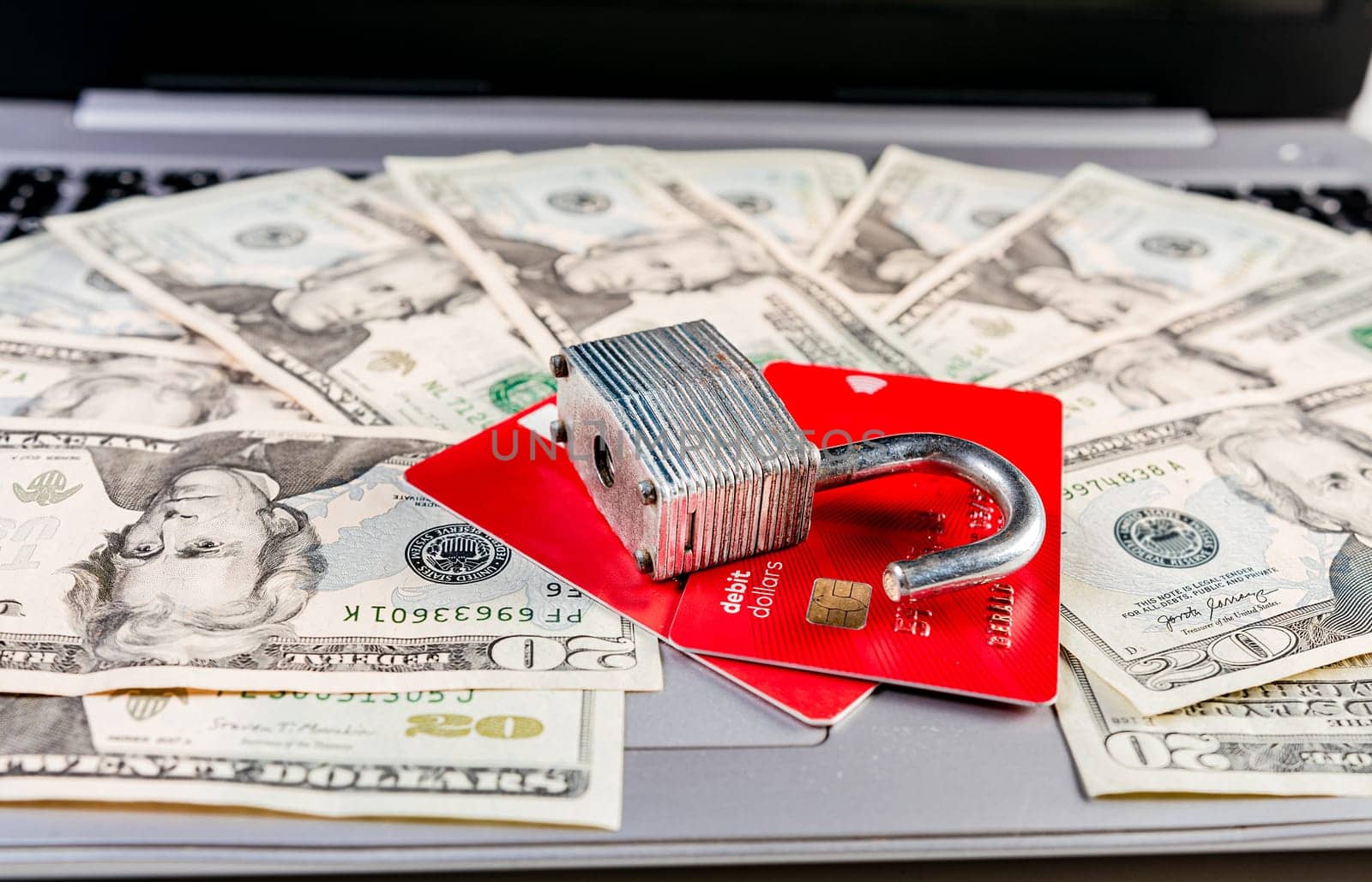 Close up of Padlock on top of credit card on dollar bills, Concept of credit card information theft. Padlock with credit card on top of dollars by isaiphoto