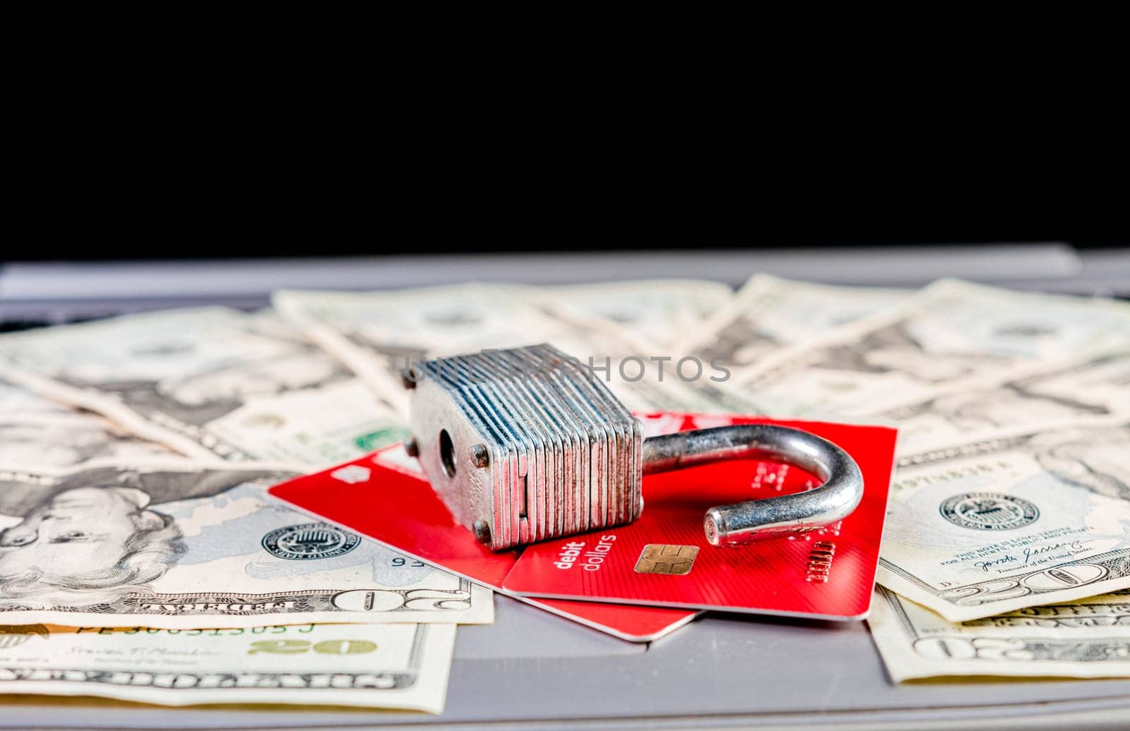 Padlock with credit card on top of dollars. Padlock on top of credit card on dollar bills, Concept of credit card information theft by isaiphoto