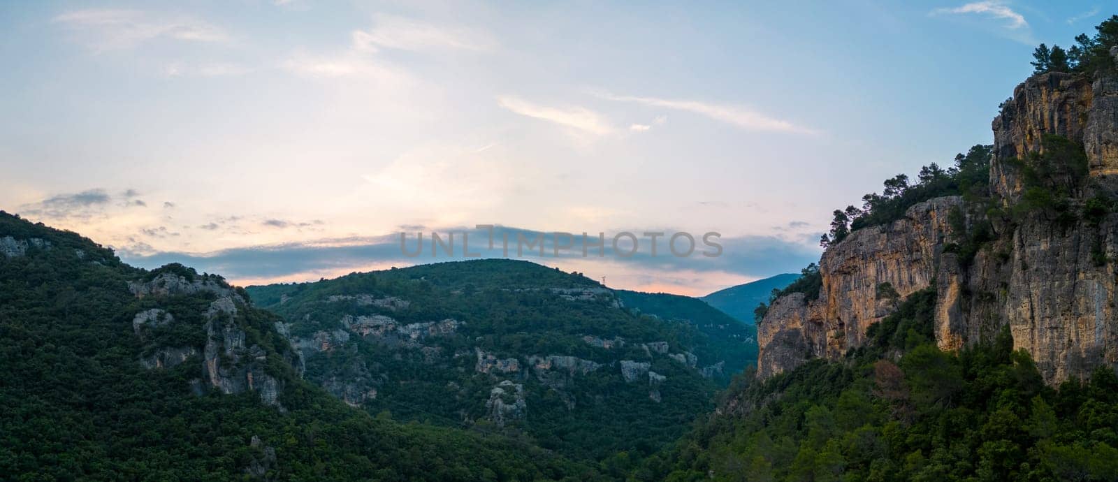 Panoramic view of steep limestone cliffs and tranquil valley at sunset. High quality photo