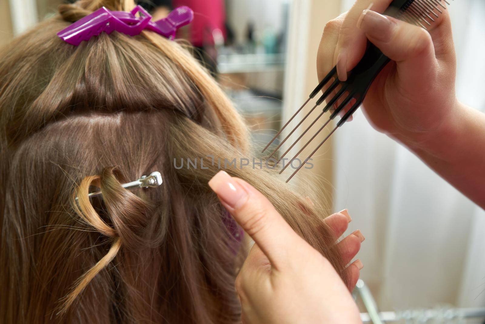 Hairdresser styling hair of a client in a beauty salon