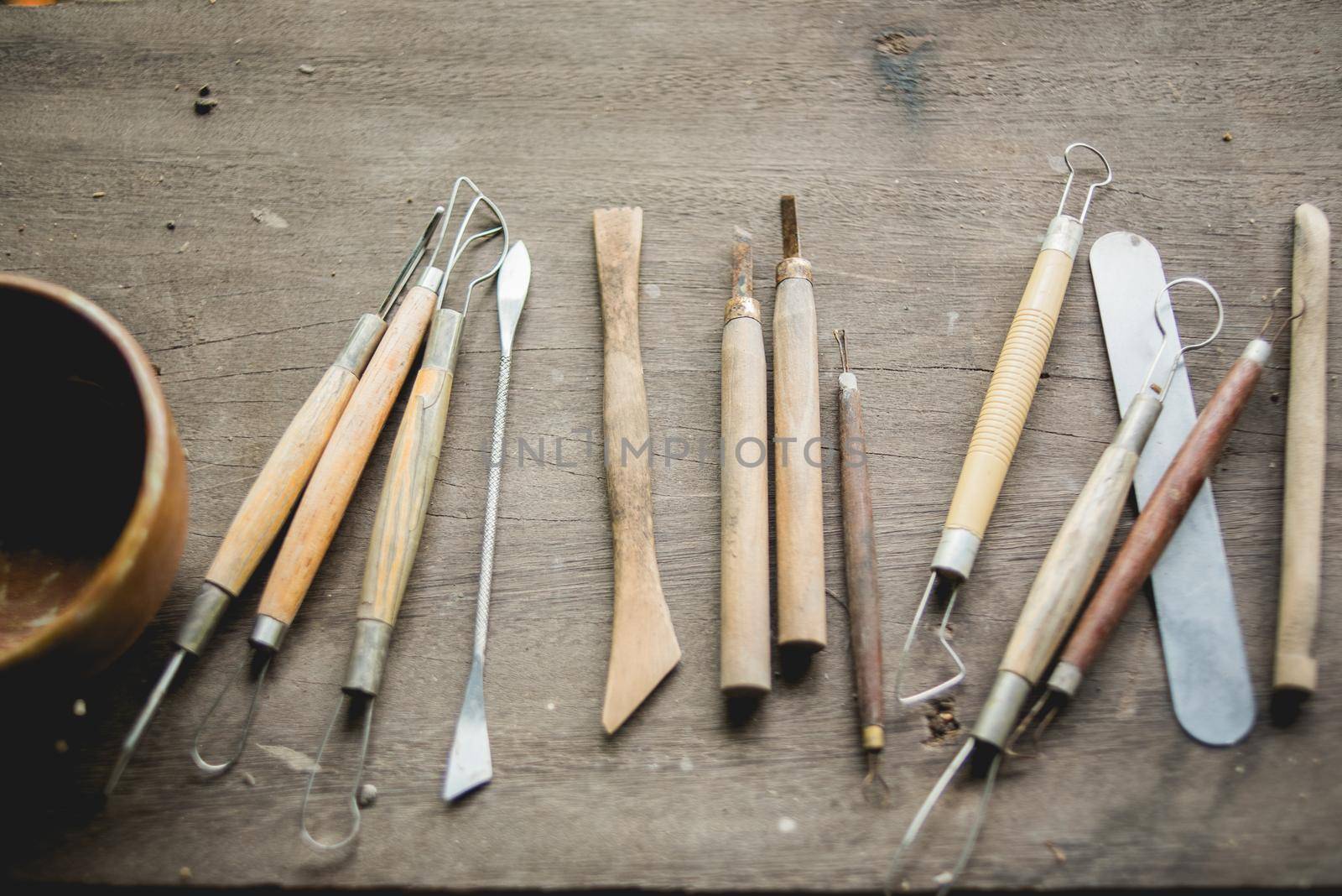 Set of dirty craft sculpting tools on wooden table by Wmpix