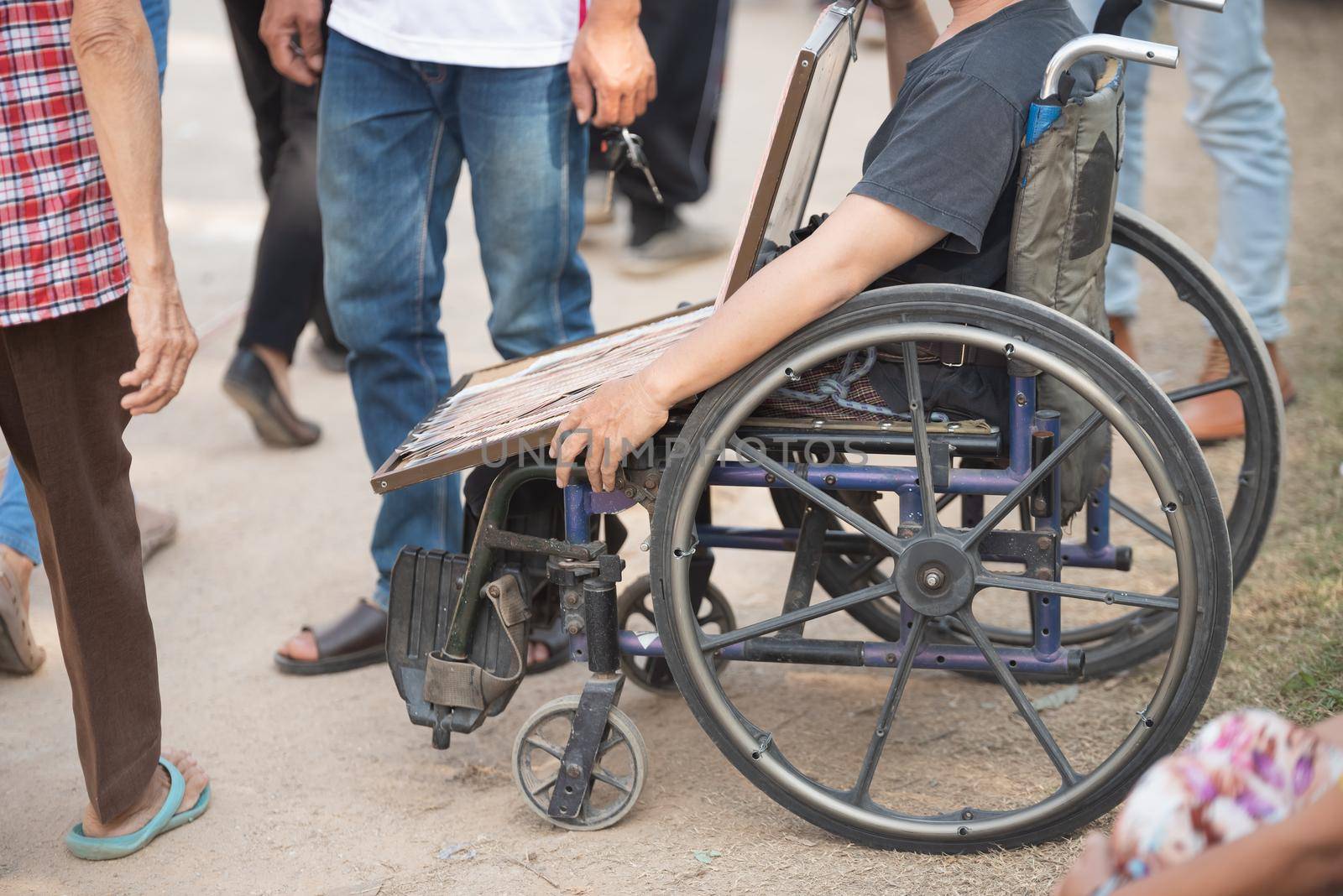 close up old man sell lottery sitting on the wheelchair