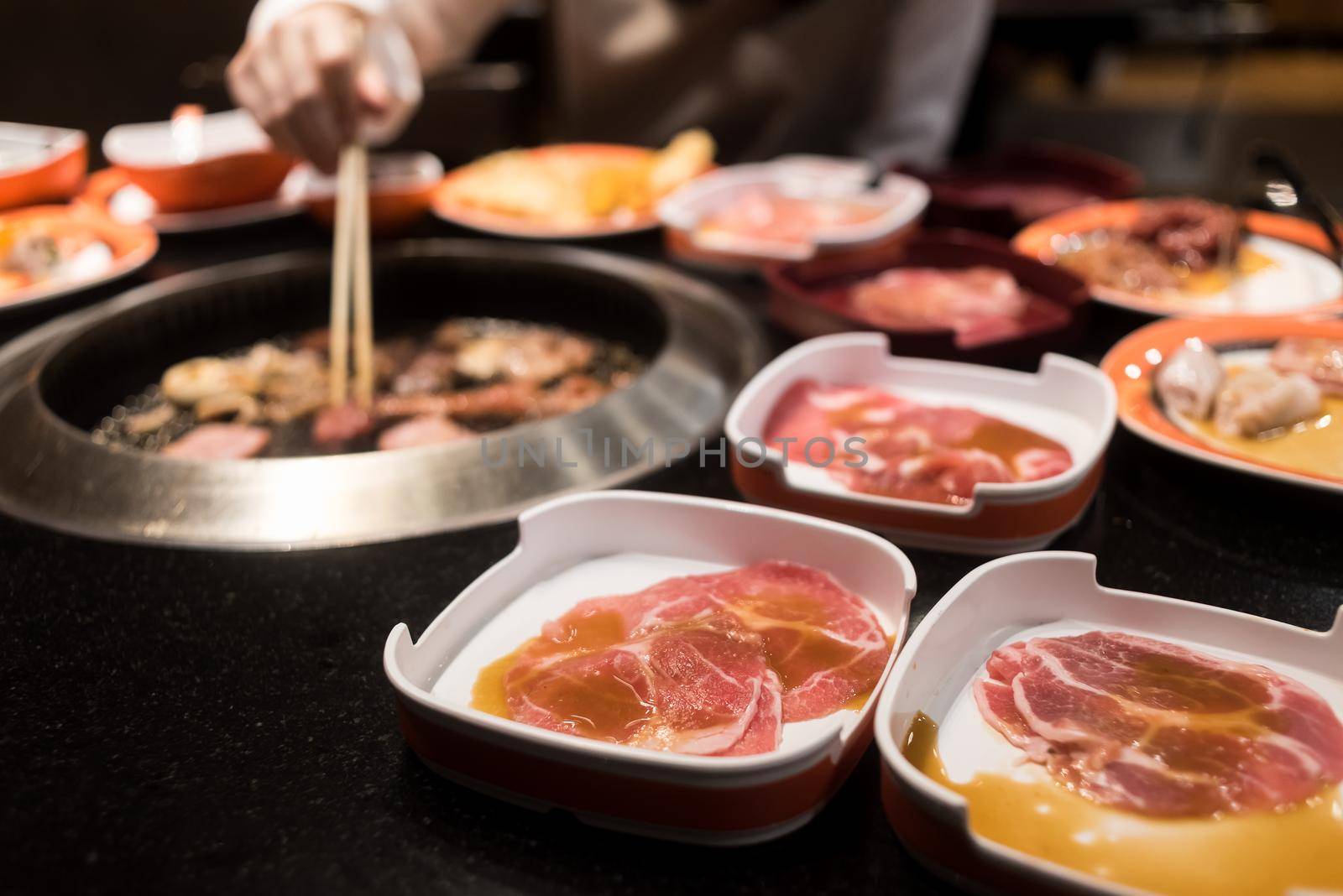 Raw beef and pork slice on grille for barbecue or Japanese style yakiniku by Wmpix