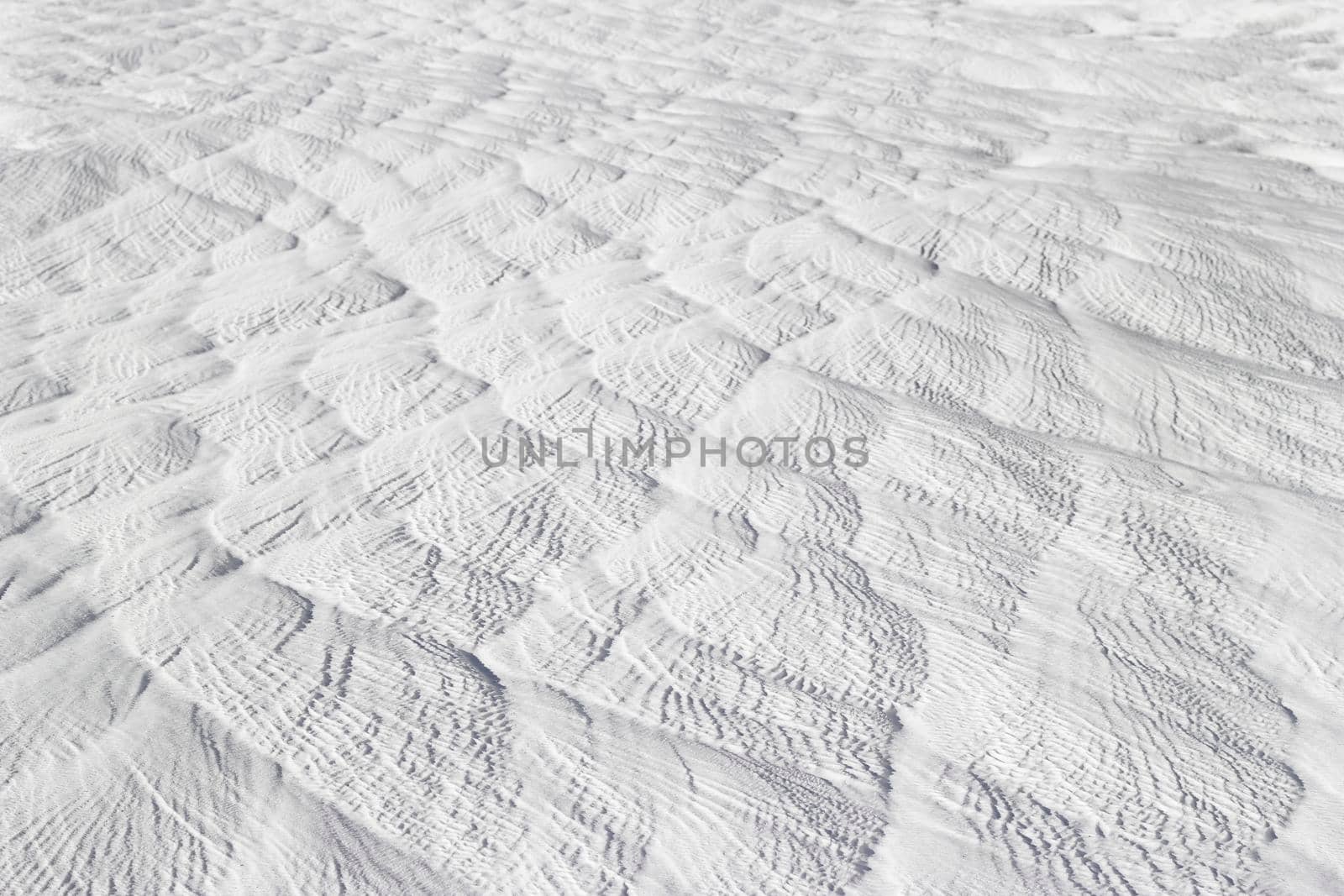 Textured effect of waves on surface of gray-white stone. Pamukkale travertine surface in Turkey.