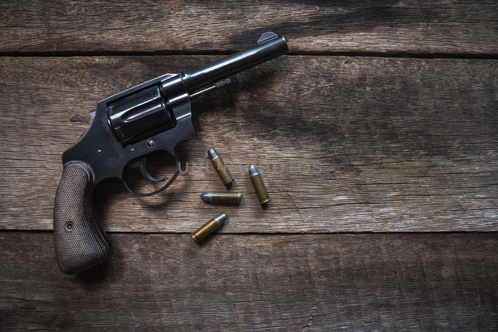 Gun and ammunition on wooden table. top view by Wmpix