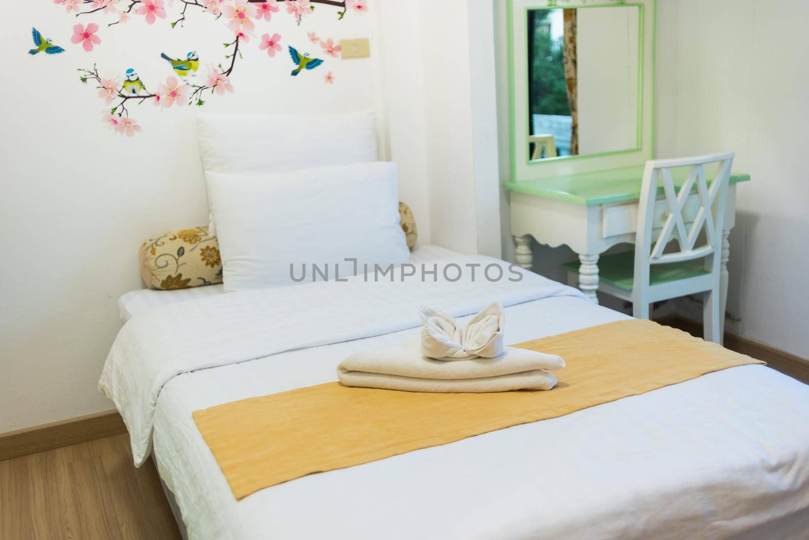 bedroom in soft light colors. big comfortable single bed in elegant classic bedroom