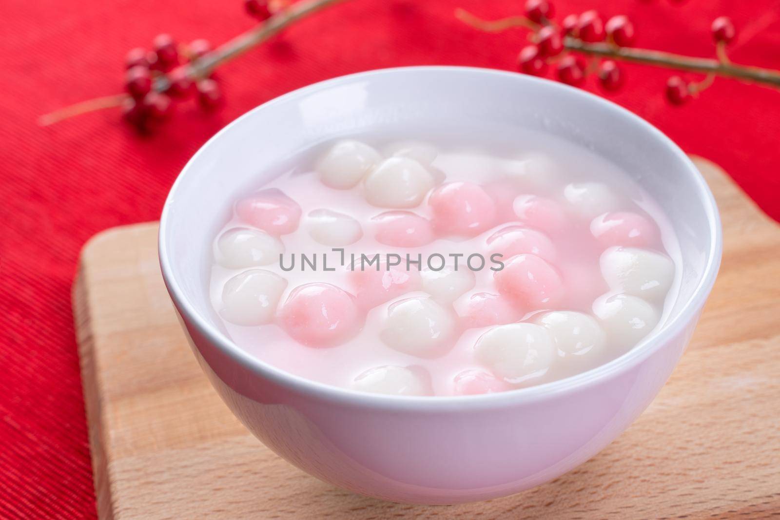 Tang yuan, tangyuan, delicious red and white rice dumpling balls in a small bowl on red background. Asian festive food for Chinese Winter Solstice Festival, close up. by ROMIXIMAGE