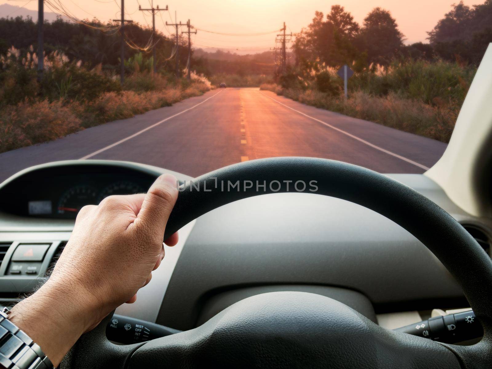 man driving car on the road by Wmpix