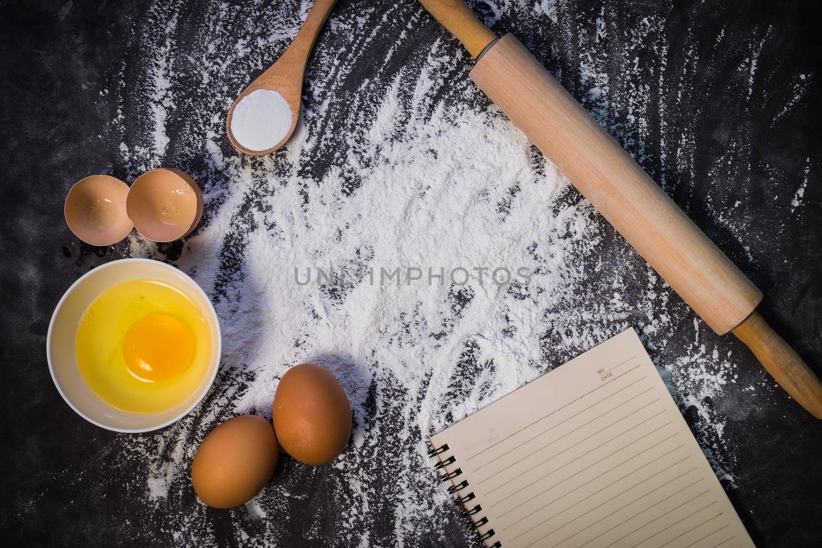 Baking background with the rolling pin with flour. On the dark table. Free space for text . Top view by Wmpix