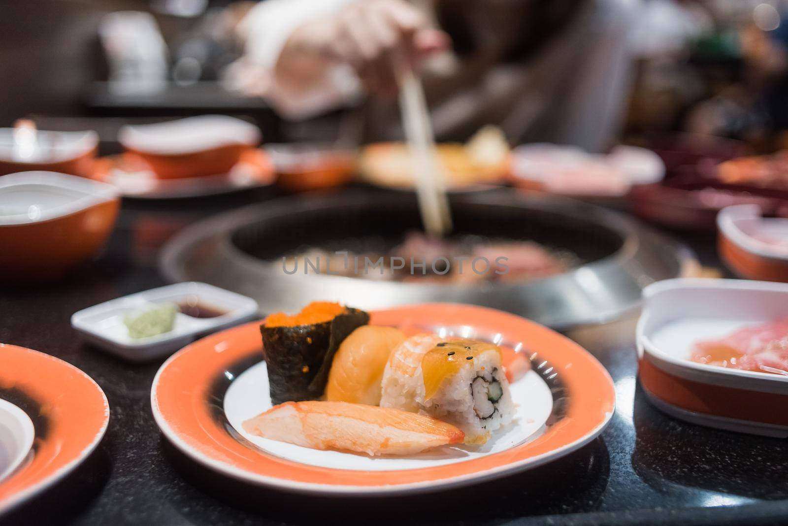 Asian girl eating sashimi set and yakiniku in the restaurant by Wmpix