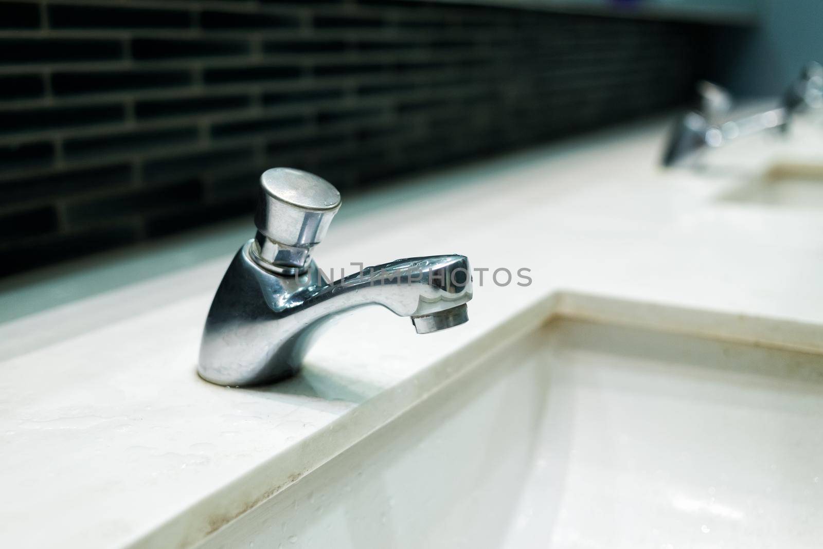 Luxury faucet on a white sink in the bathroom by Wmpix