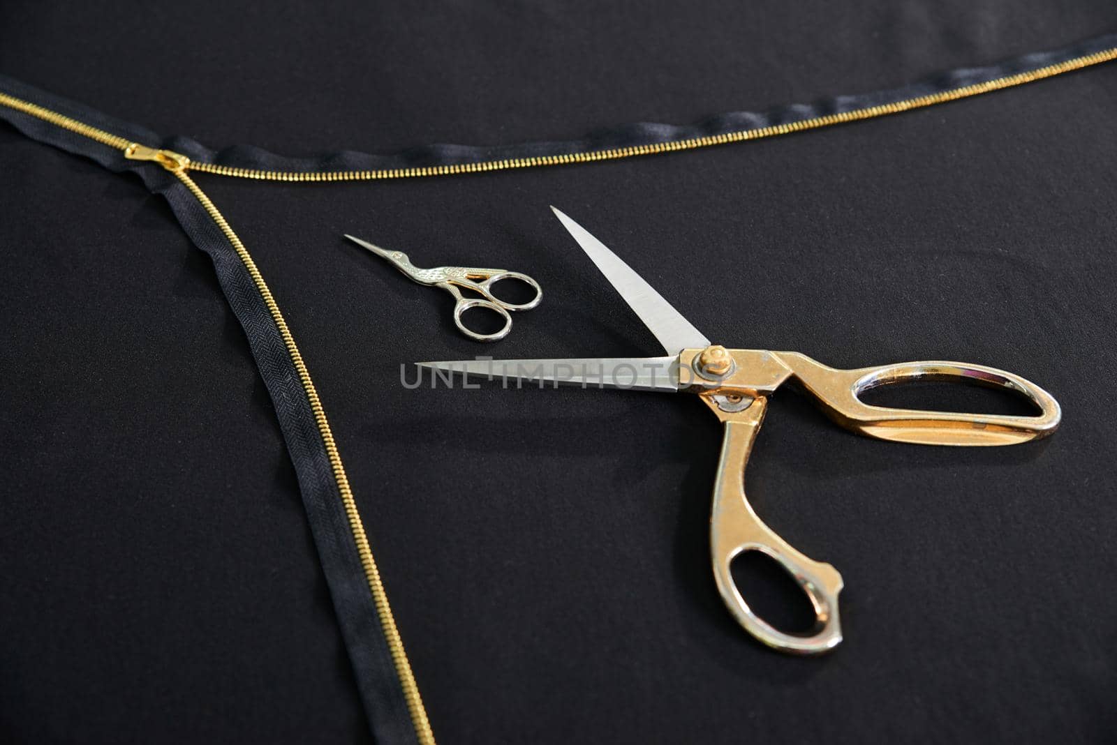Tailor background with open golden zipper and two scissors