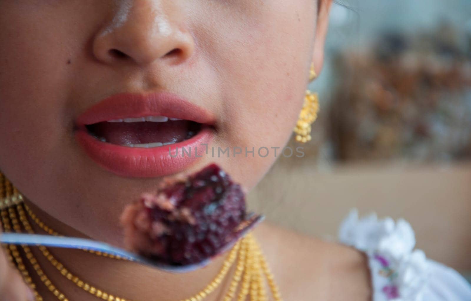 closeup of indian teenager with open mouth about to eat a piece of cake. High quality photo