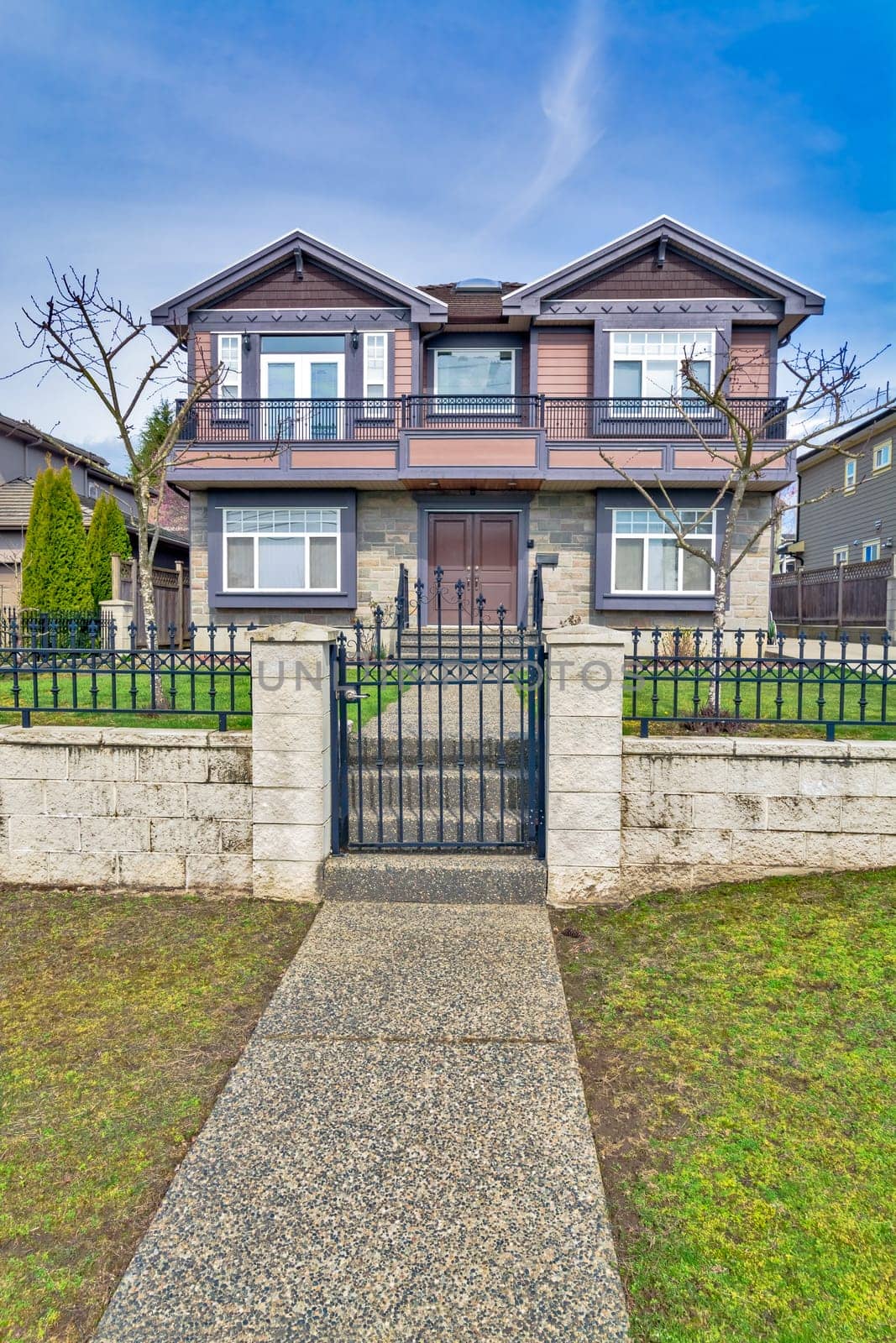 Big residential house with metal fence and gate on winter day in Canada