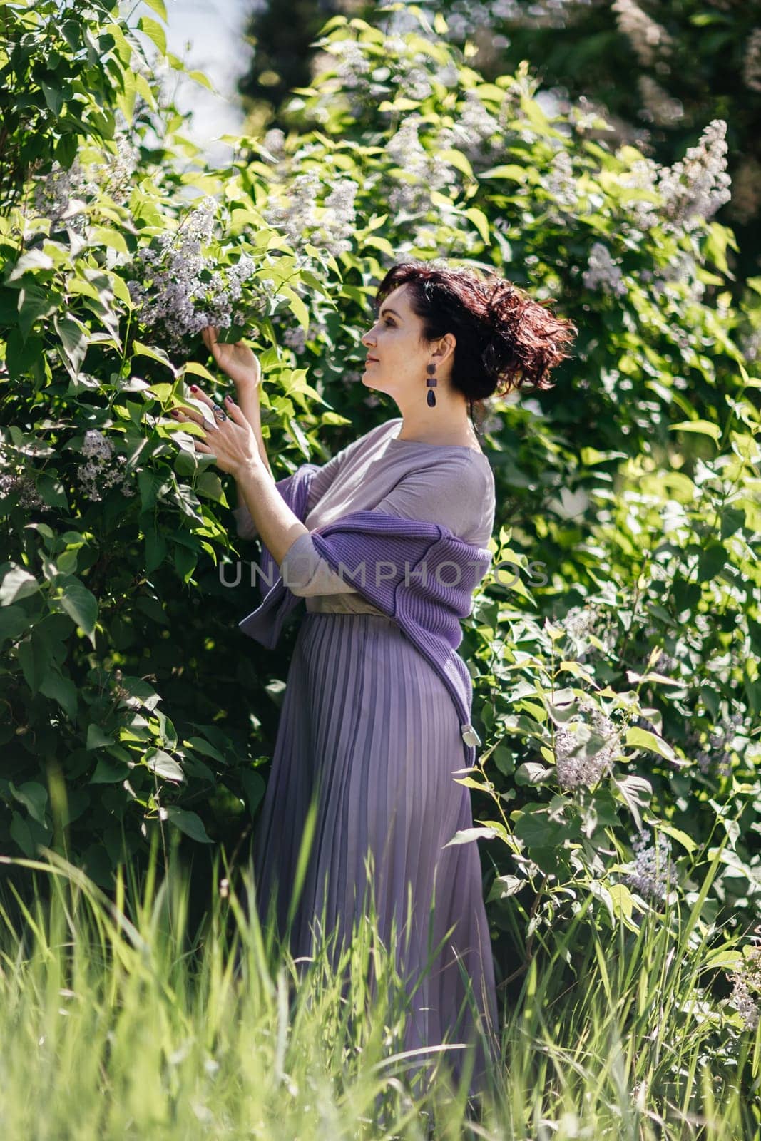 Woman lilac. Portrait of an happy woman surrounded by lilac bushes. Spring seasonal photos. by Matiunina
