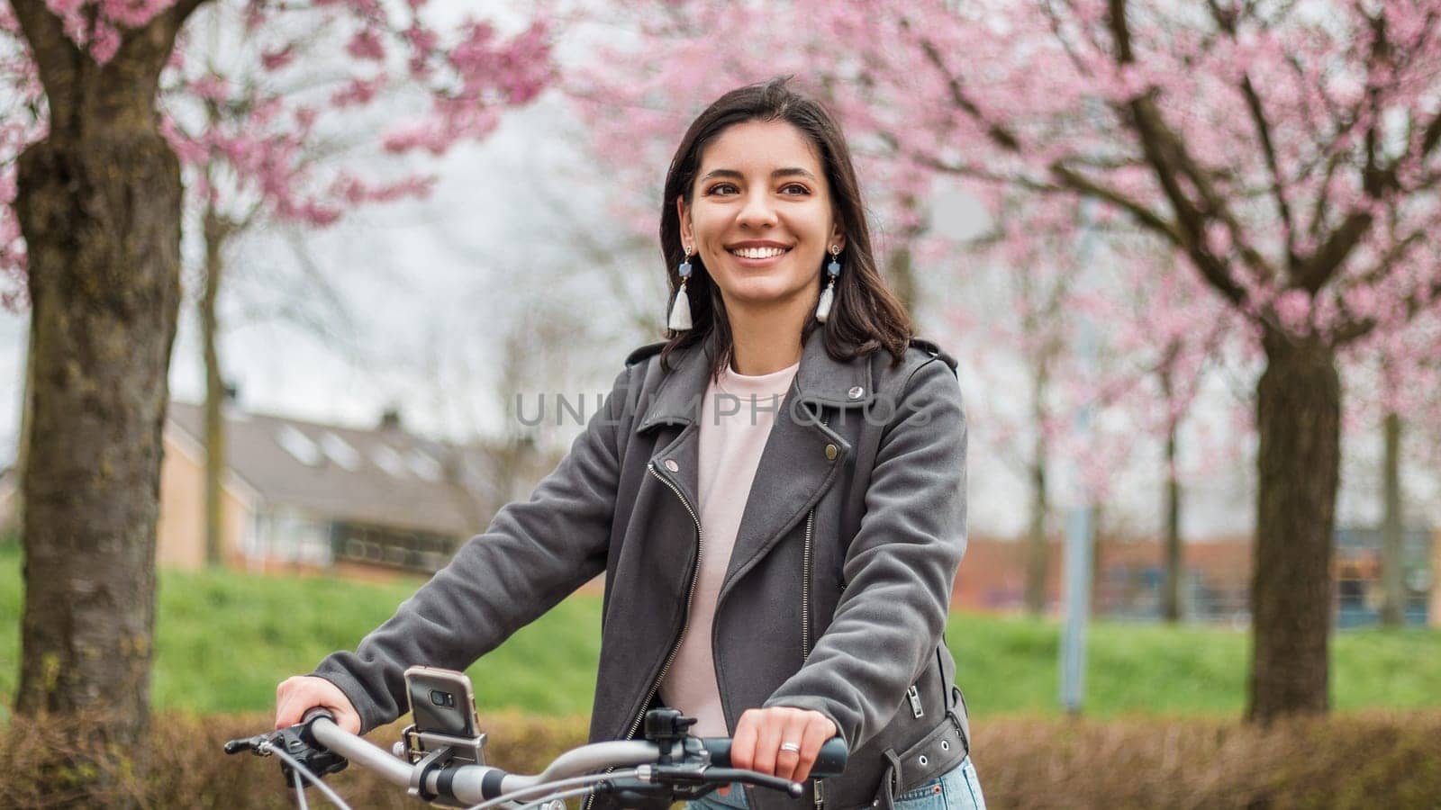 Close portrait of beautiful multi-ethnic Turkish woman 20-29s riding a bike in the city street by AndreiDavid