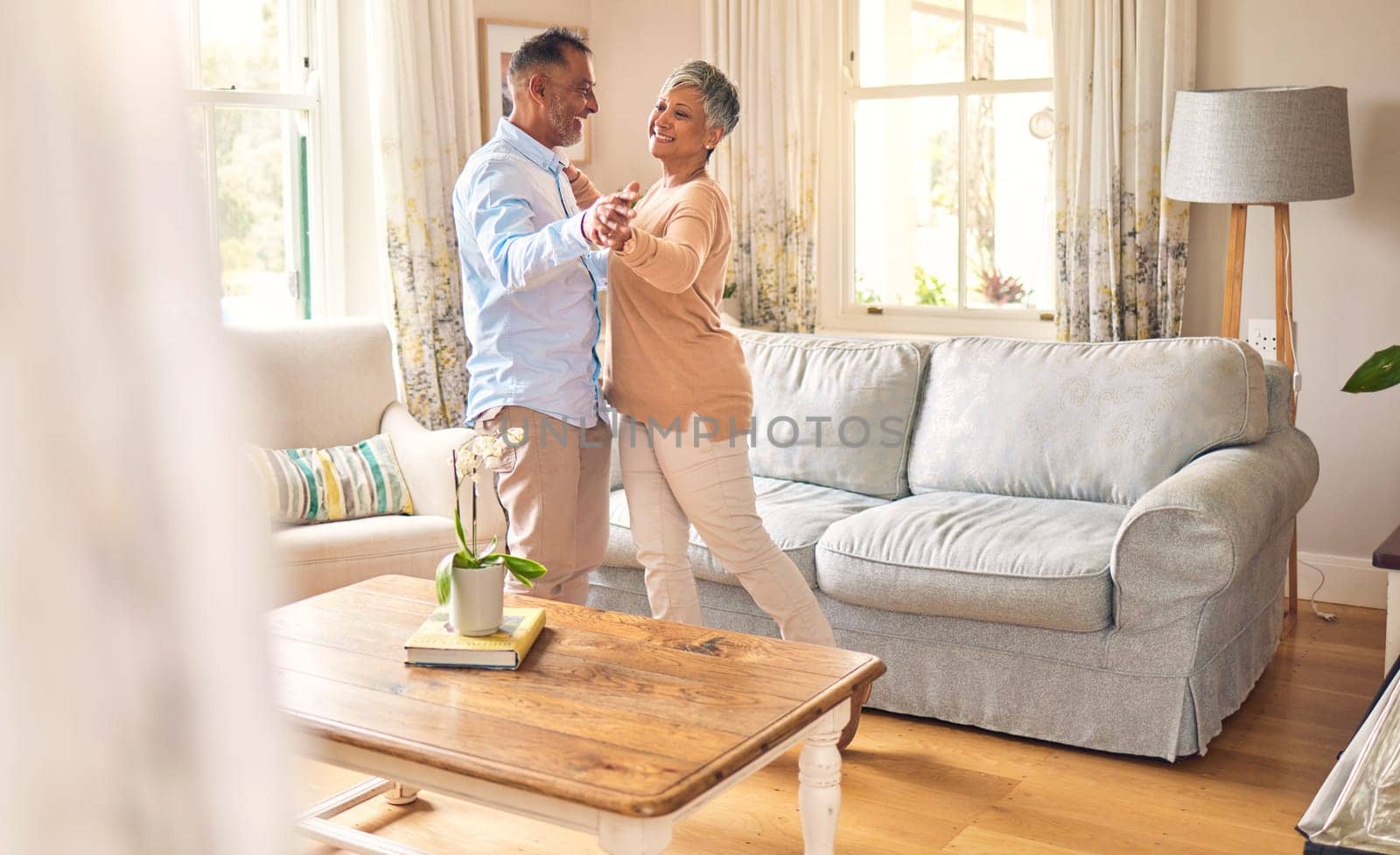 Love, retirement and dance with a senior couple in the living room of their home together for bonding. Marriage, romance or bonding with an elderly man and woman dancing in the lounge of their house.