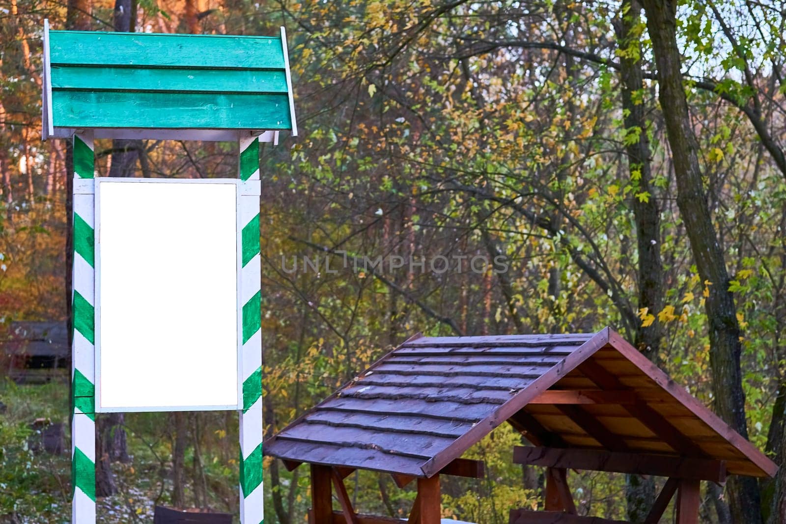 Wooden shield billboard in a green frame for text, a gazebo for a forest picnic by jovani68