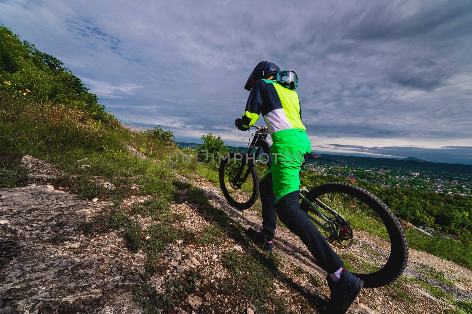 mountain biker carries a bicycle in a forested landscape of summer mountains. MTB track for cycling. Outdoor sports, the guy carries the bike to the top by yanik88