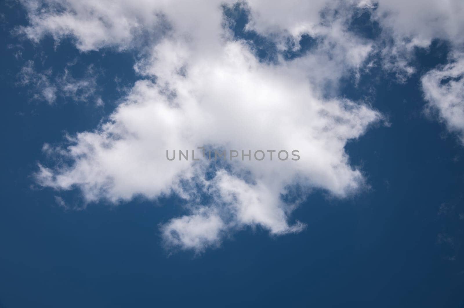 Close-up of a white cloud against a dark blue sky. cloud background.