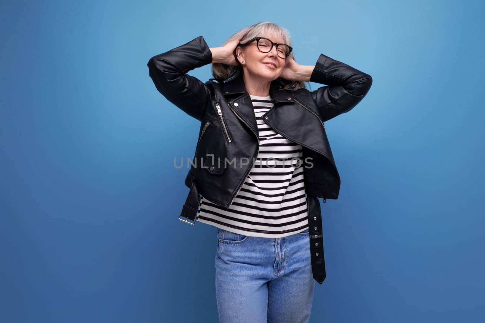 energetic mature woman in a stylish jacket on a bright background.