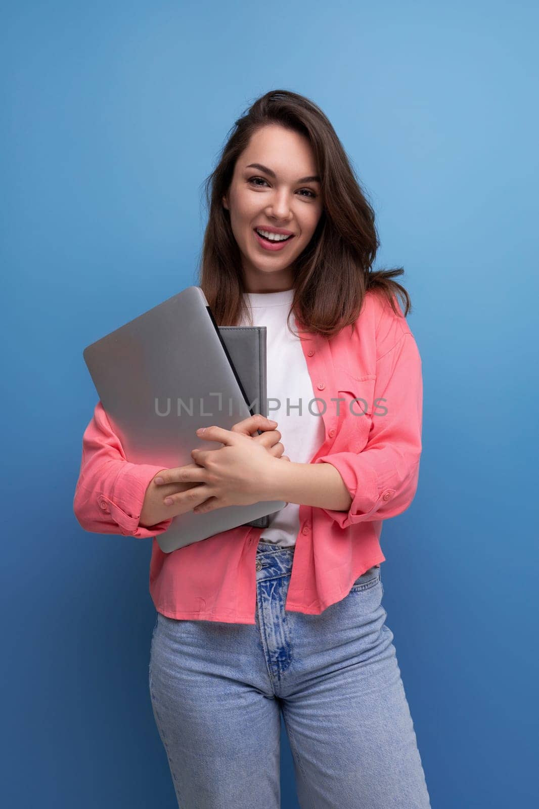 confident brunette young business woman in shirt and jeans with laptop.