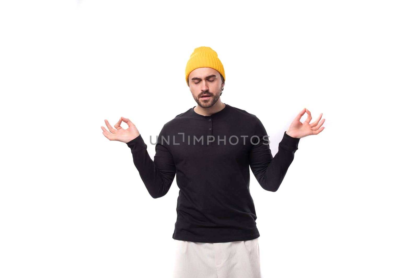 well-groomed authentic brunette male adult in a black sweater is meditating.