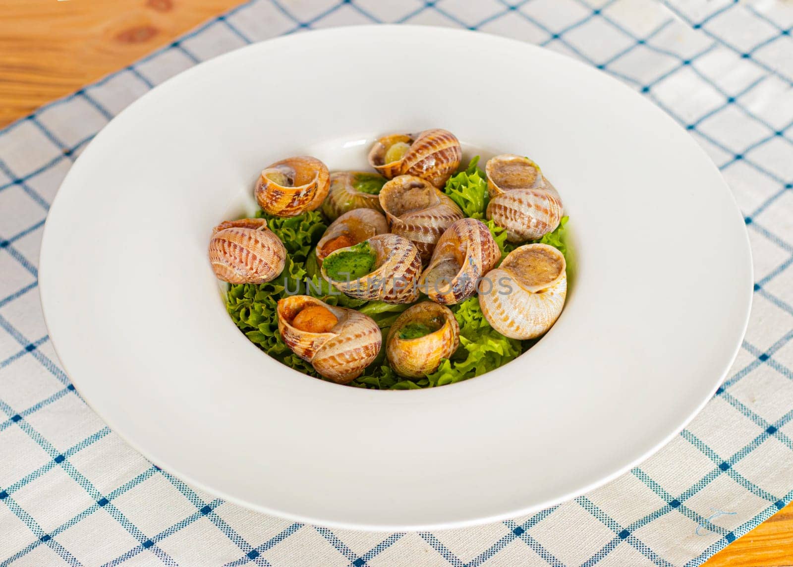 snails dishes, snails ready to eat. Restaurant serving in a deep white plate. Serving dish, snails in a plate. dinner in a restaurant. photo for restaurant menu