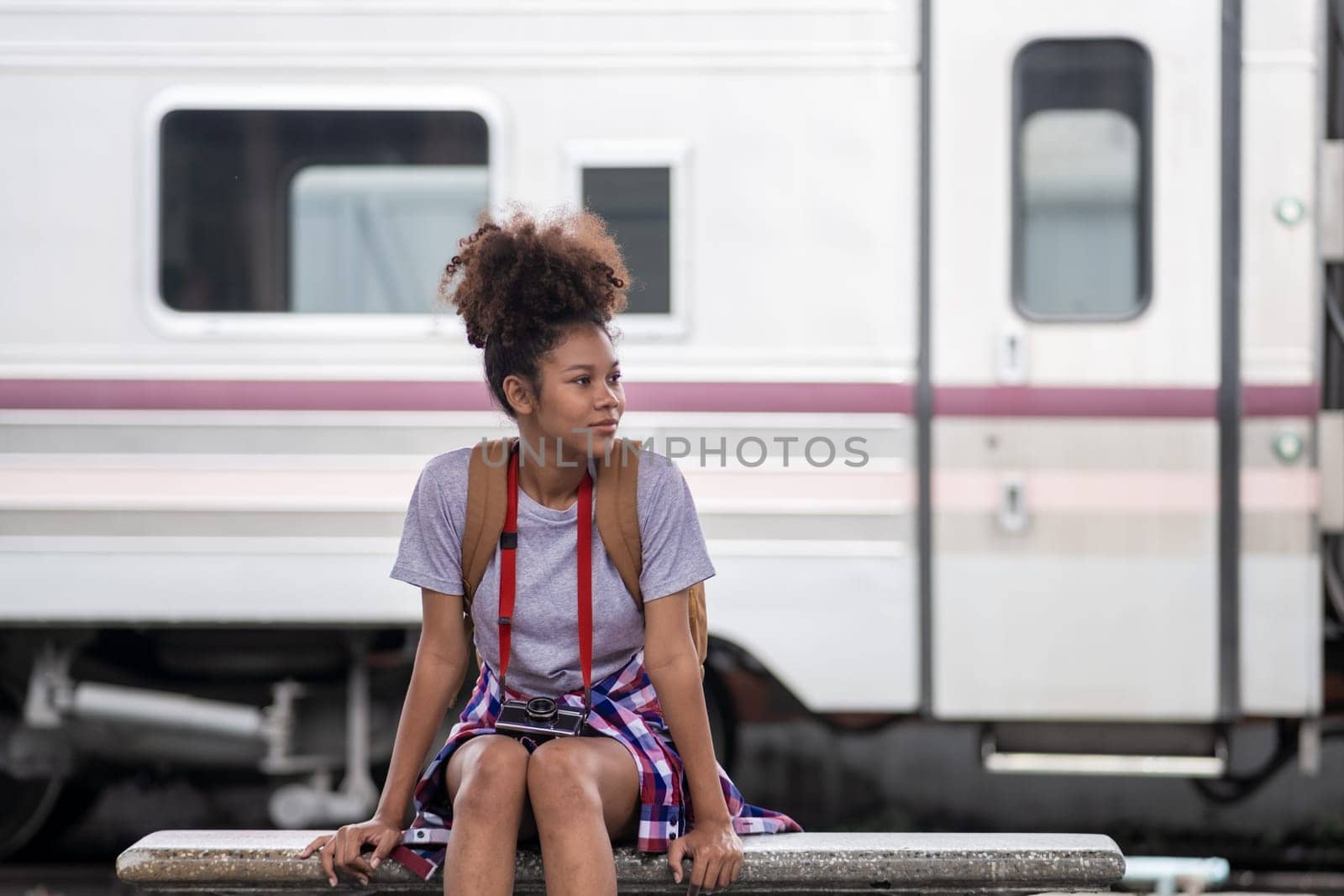 Traveler African Asian American woman getting in a train to hop on train, Young woman female standing on train door peeking out looking from door, tourist on a train station. High quality photo