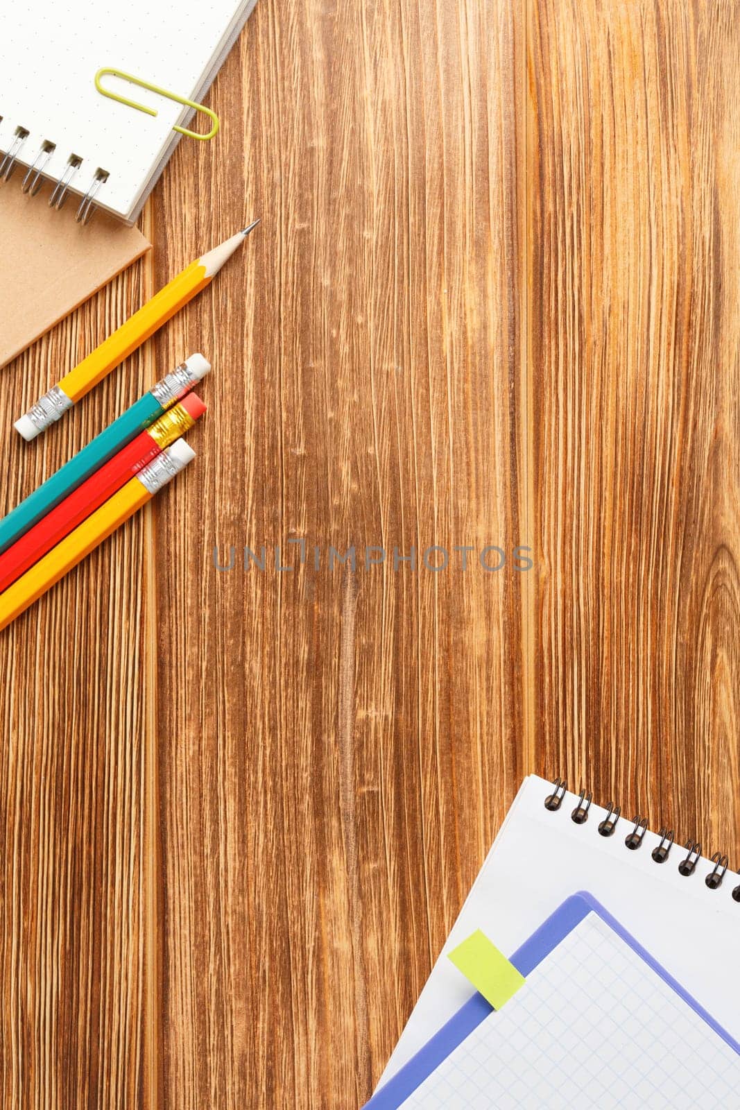 Open spiral notebook with a pencil on a wooden background. Study desk. Flat lay. Back to school concept. Top view.