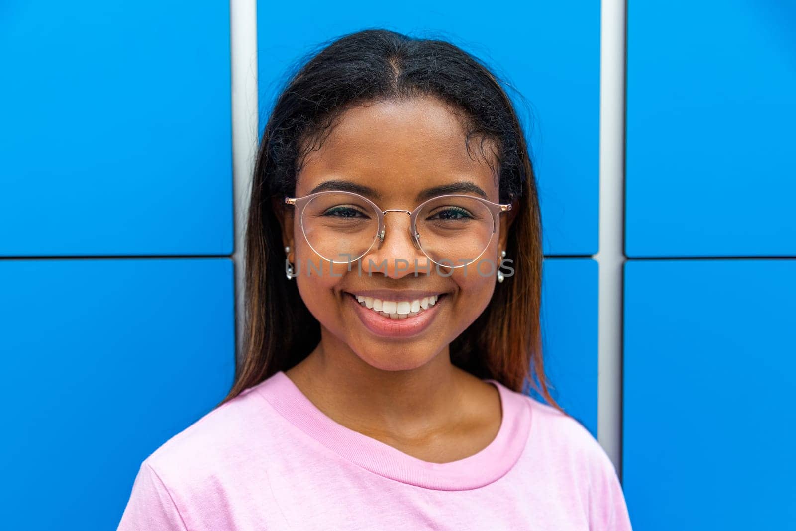 Portrait of happy teen african latina female high school student looking at camera wearing glasses. Education concept.
