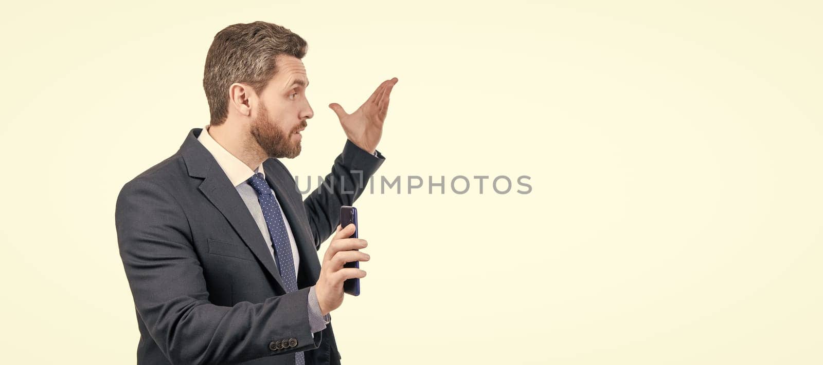 Dont bother me. Angry businessman hold smartphone. Business call. Mobile call. Man face portrait, banner with copy space. Business man in suit, isolated studio background