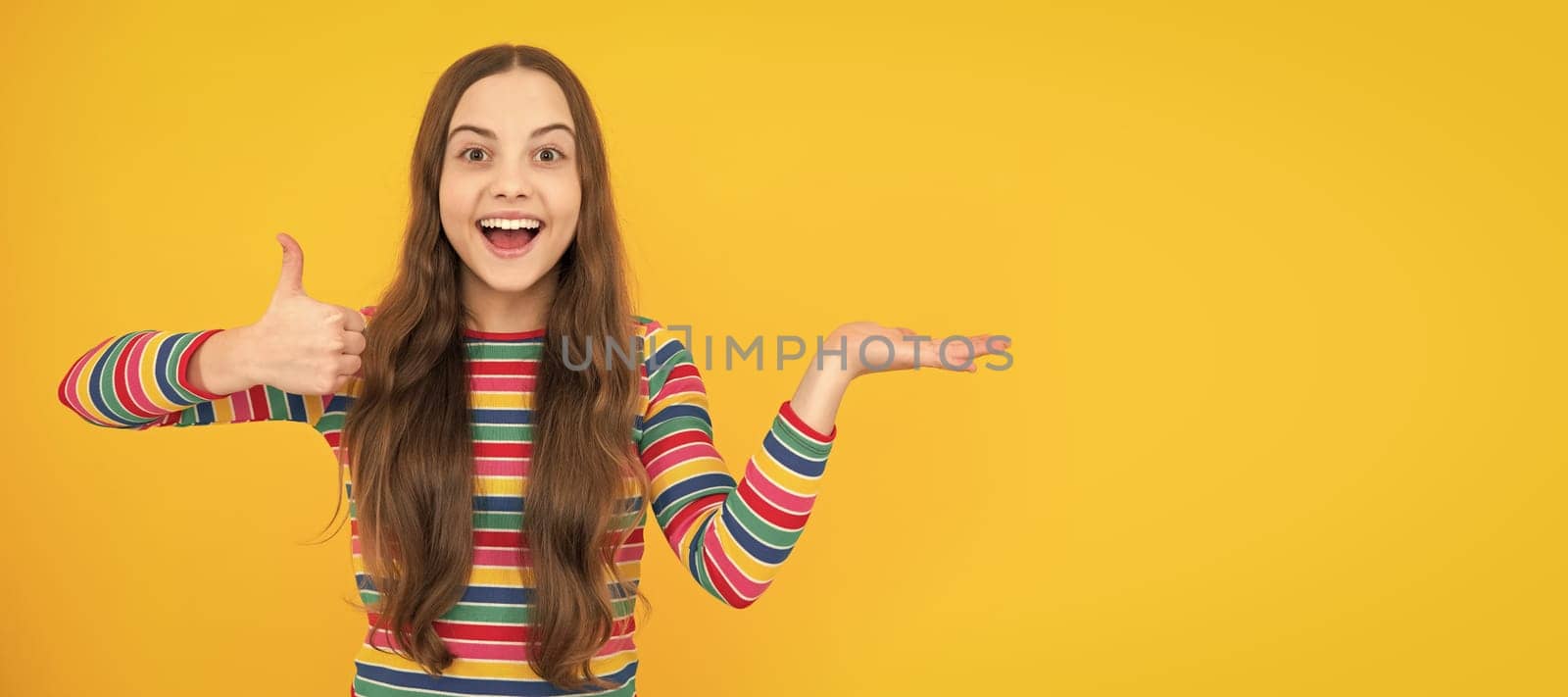 Impressed teenage girl showing recommendation copyspace. Child face, horizontal poster, teenager girl isolated portrait, banner with copy space