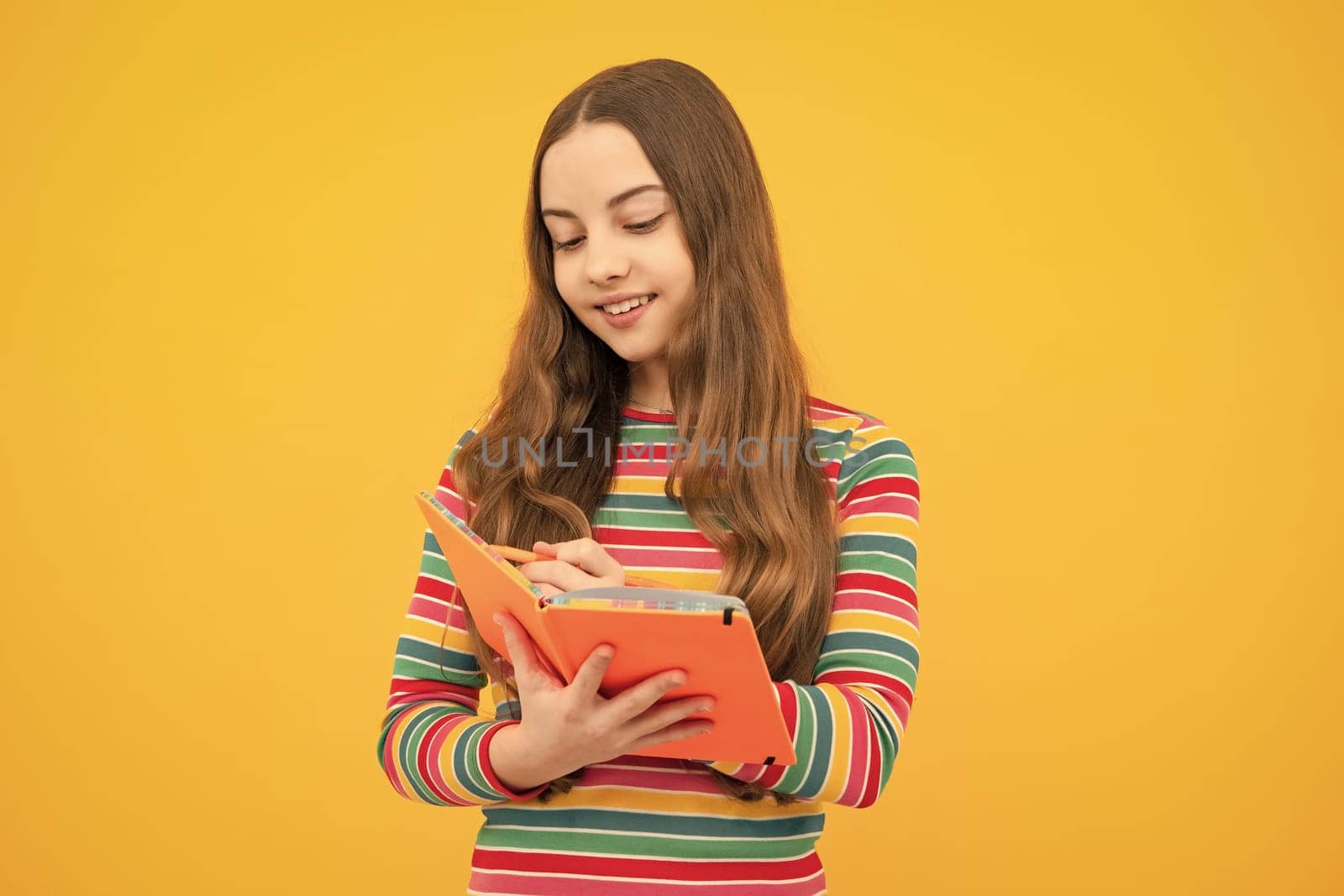 Schoolgirl with copy book posing on isolated background. Literature lesson, grammar school. Intellectual child reader