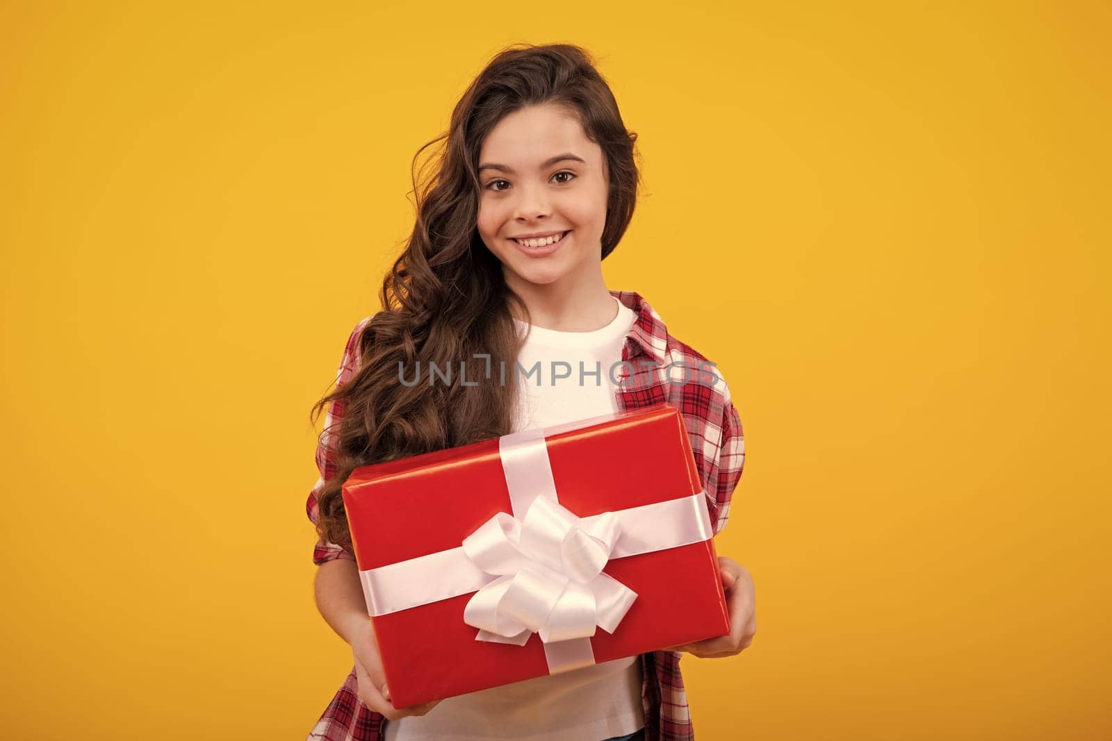 Child with gift present box on isolated background. Presents for birthday, Valentines day, New Year or Christmas. Happy teenager, positive and smiling emotions of teen girl