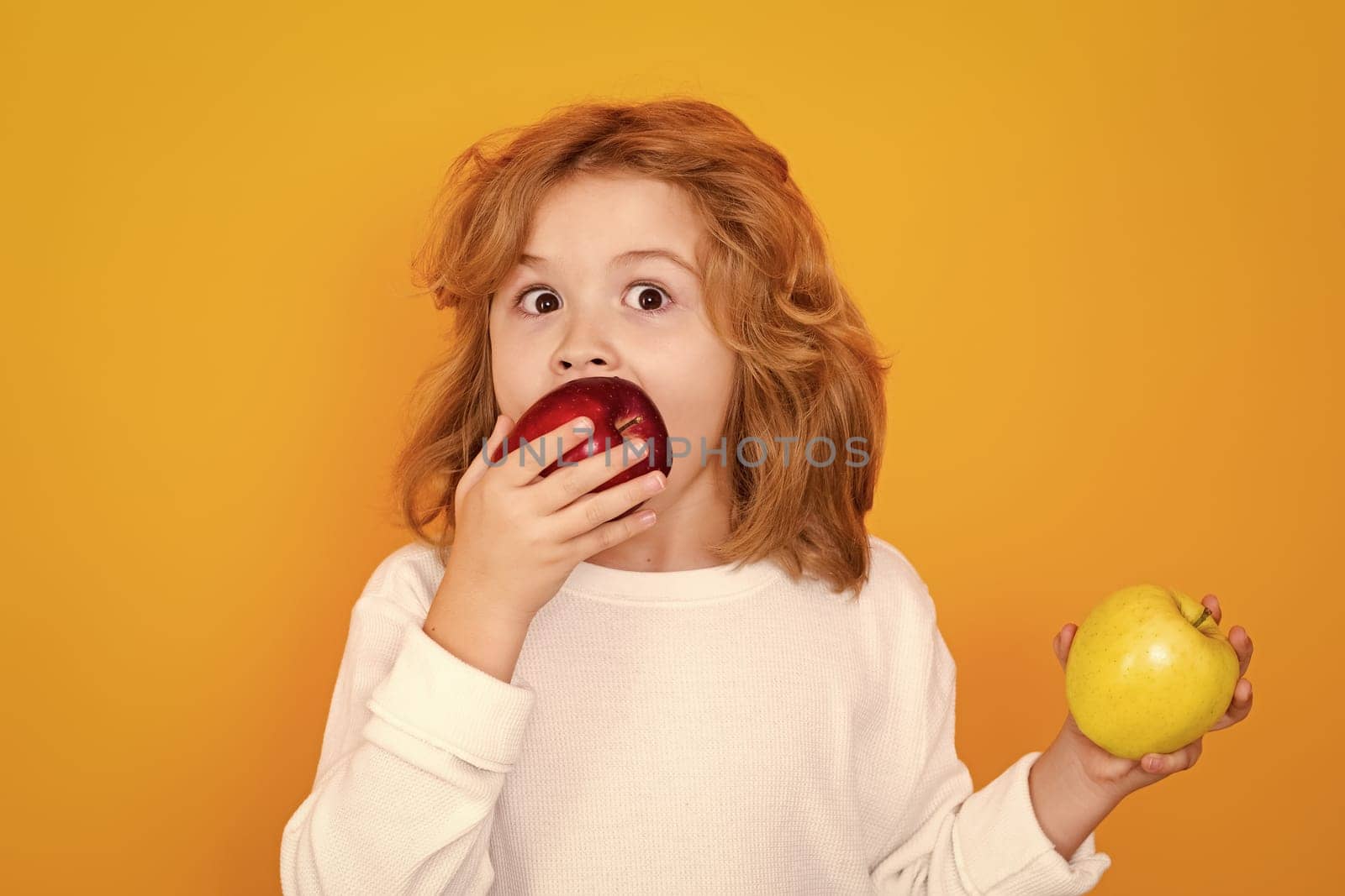 Vitamin and healthy fruits for kids. Kid with apple in studio. Studio portrait of cute child hold apple isolated on yellow background