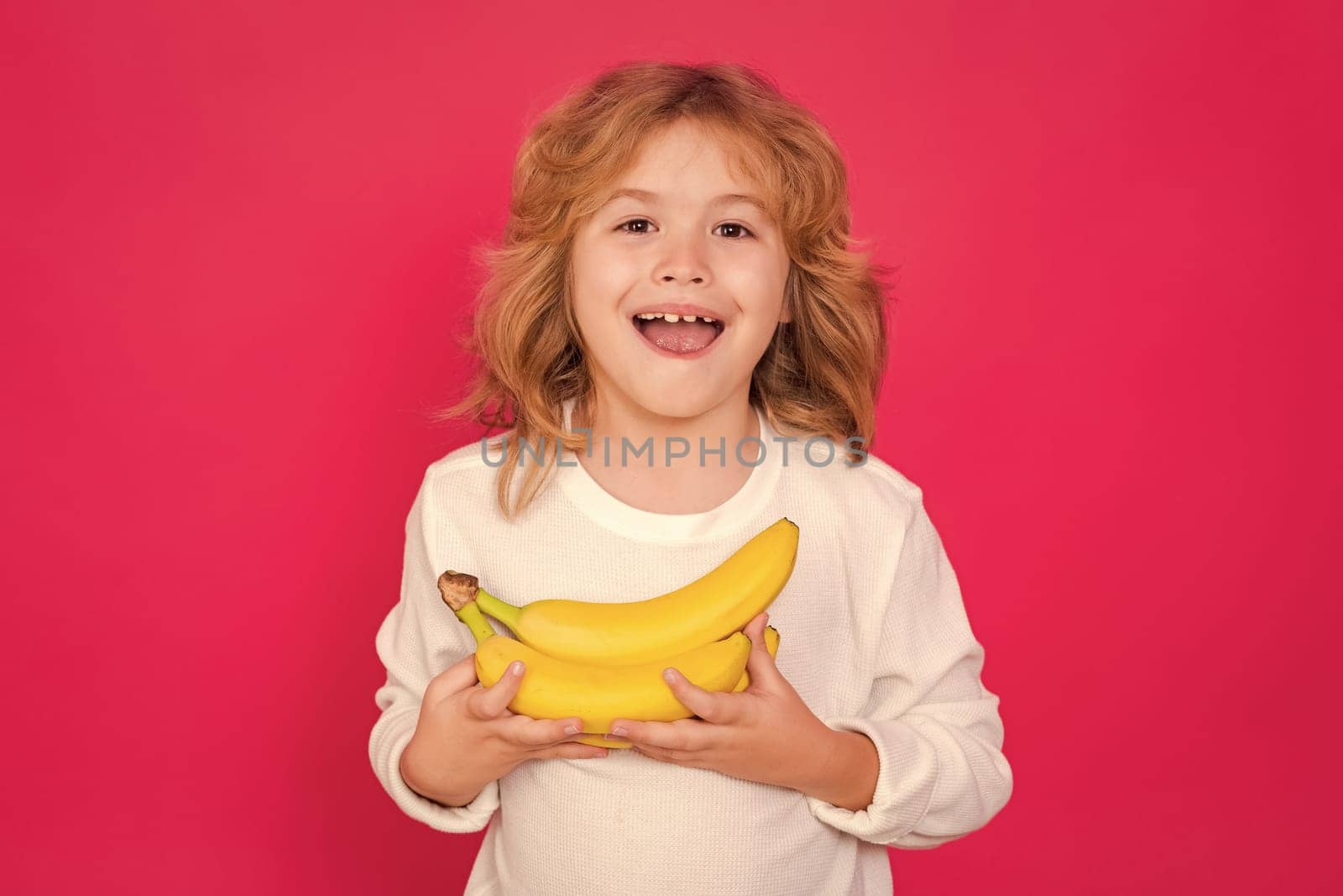 Vitamin and healthy fruits for kids. Kid hold dragon fruit in studio. Studio portrait of cute child with dragon fruit isolated on yellow background, copy space