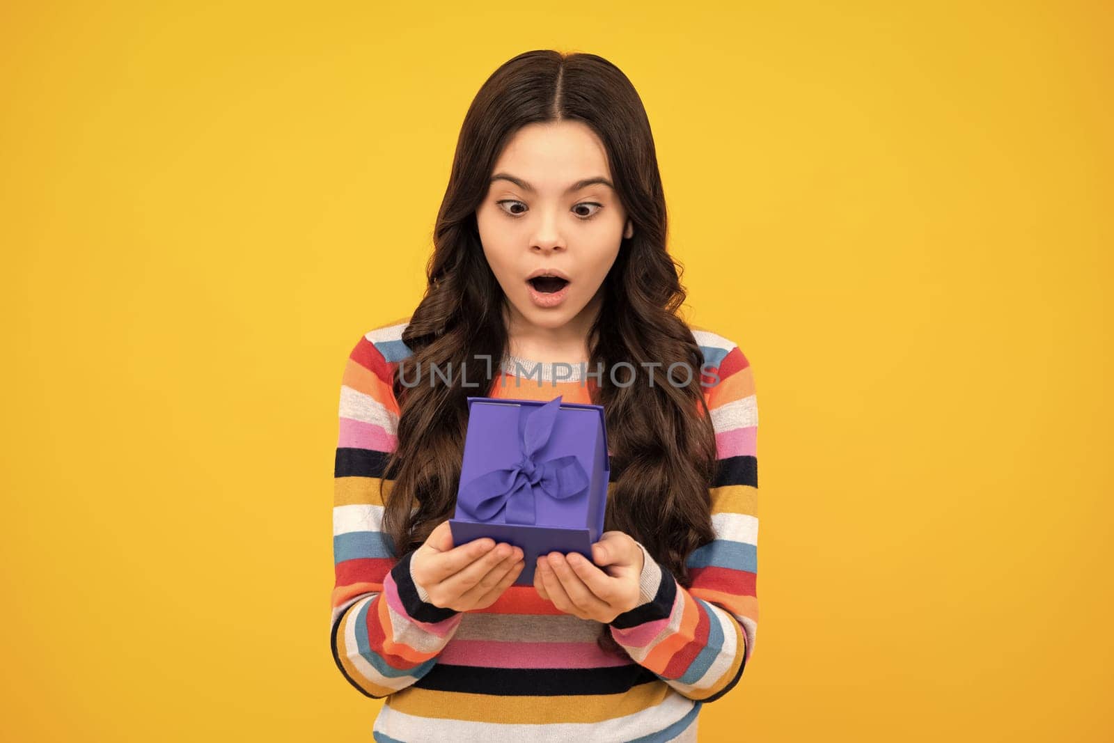 Shocked amazed face, surprised emotions of young teenager girl. Teenager kid with present box. Teen girl giving birthday gift. Present, greeting and gifting concept