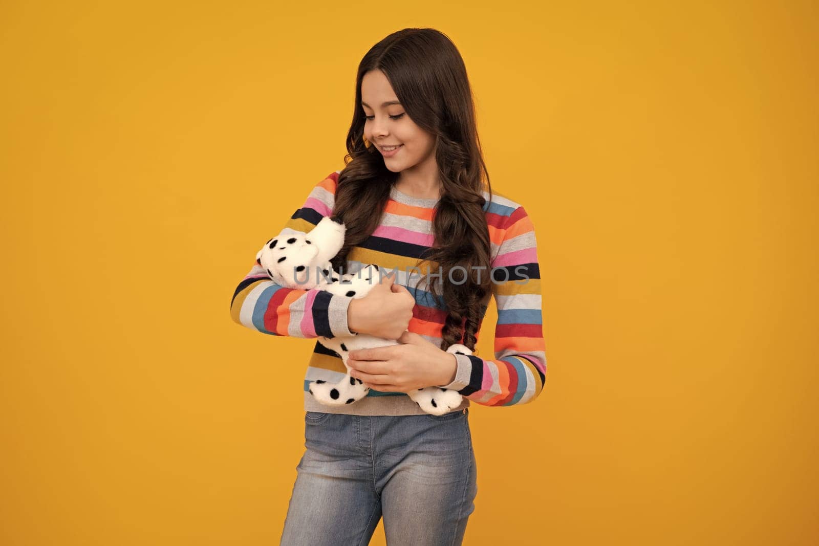 Teenager child girl in holding plush toy isolated on yellow background, happy childhood. Happy teenager, positive and smiling emotions of teen girl. by RedFoxStudio