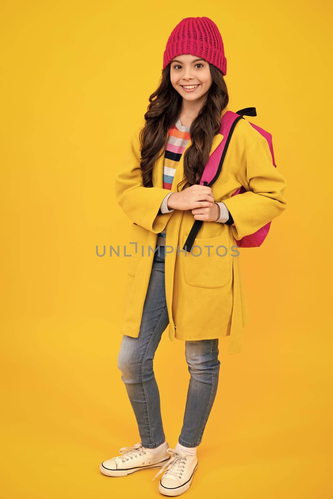 Autumn school. Teenager schoolgirl in school uniform with bagpack. School children on isolated studio background. 1 september, knowledge day