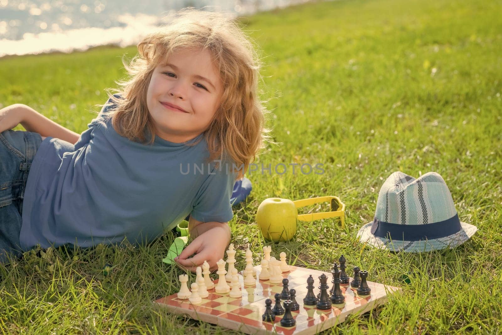 Child playing chess. Clever kid thinking about chess