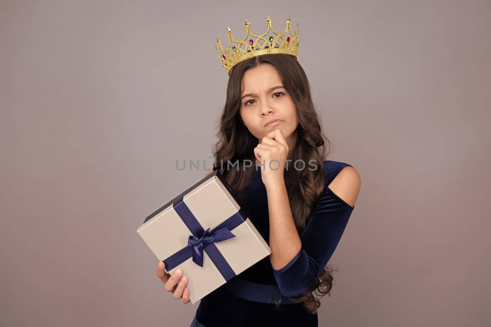 Serious teenager girl princess in crown. Cute teenager child girl congratulate with valentines day, giving romantic gift box. Present, greeting and gifting concept. Birthday holiday concept. by RedFoxStudio