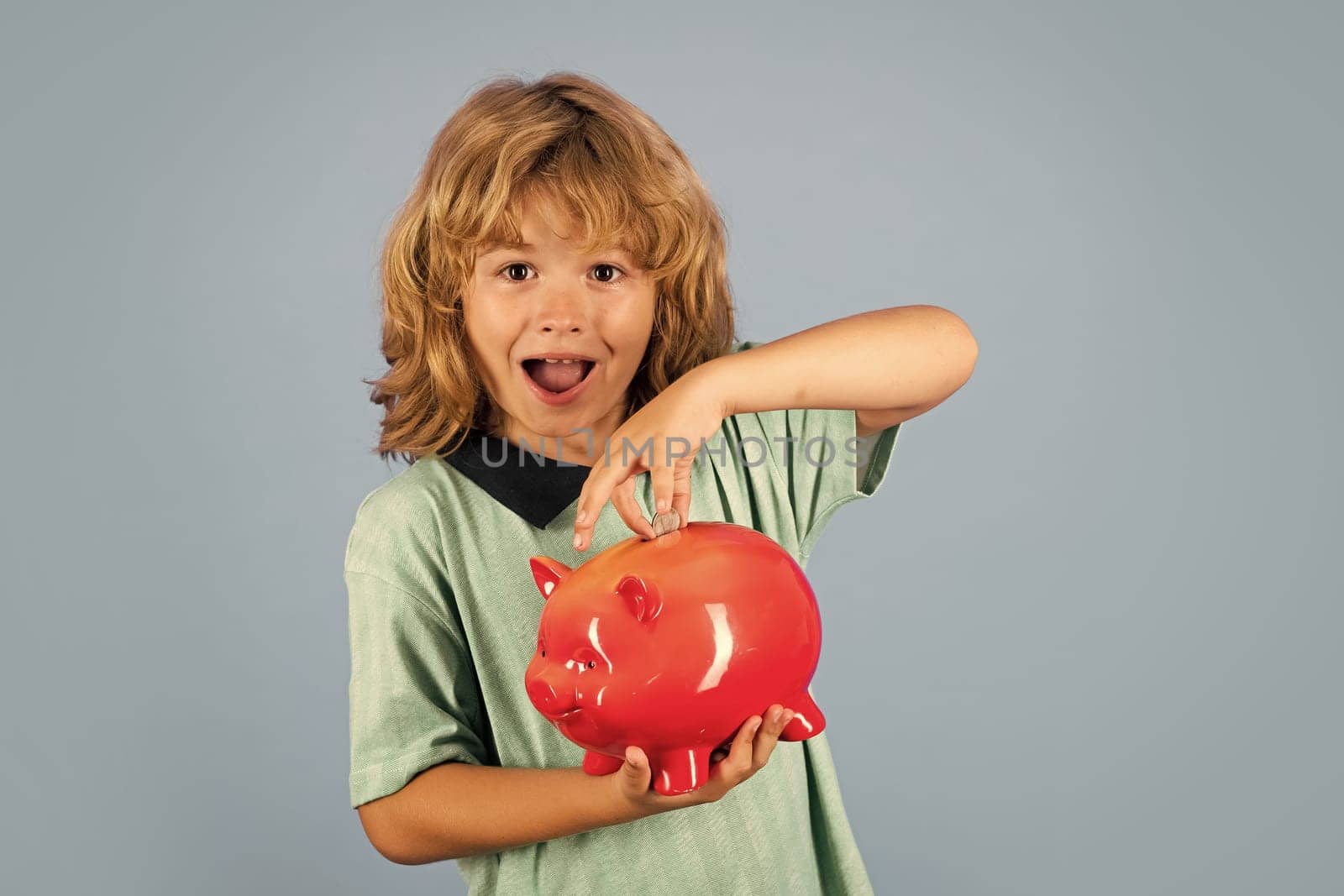 Saving money concept. Child boy putting in piggy bank usd coin