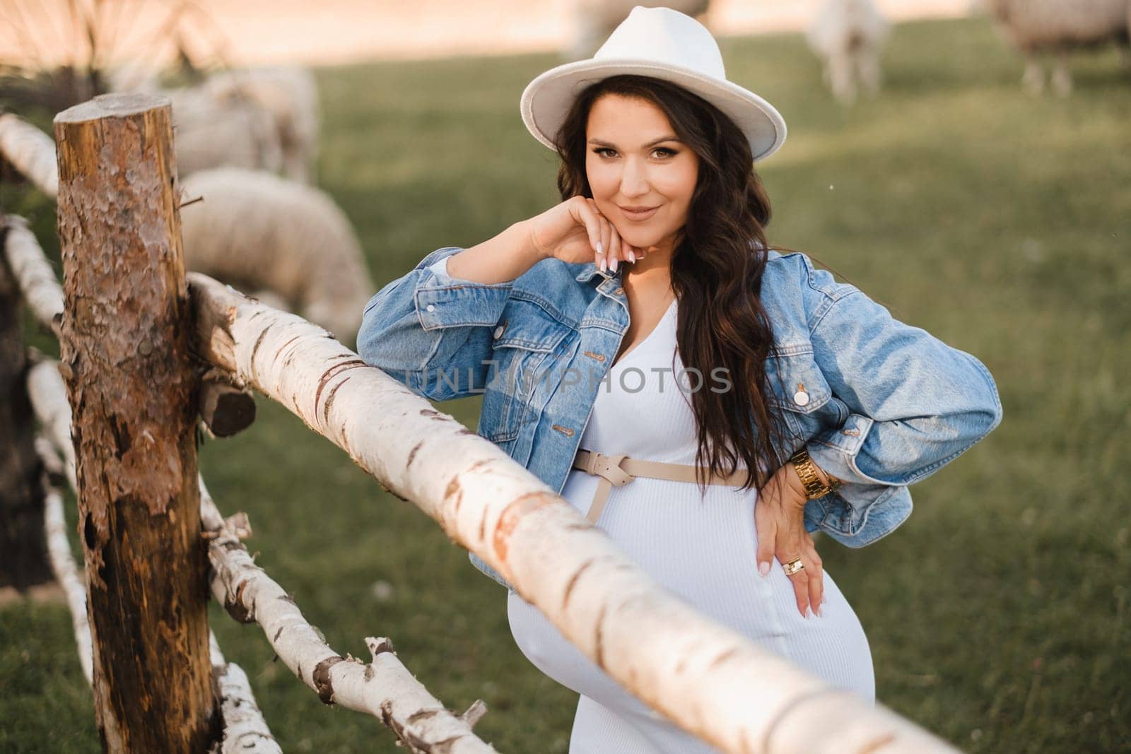 Stylish pregnant woman in a white hat in the countryside by Lobachad