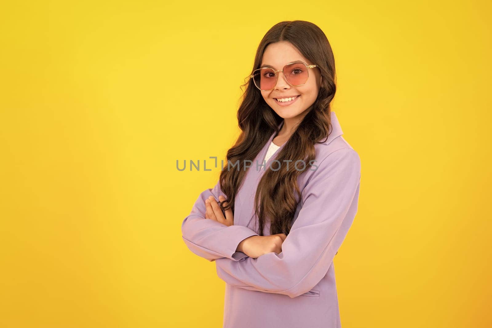 Portrait of caucasian teen girl with arms folded, isolated on yellow background. Cute teenager child