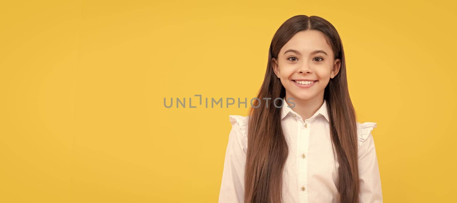 smiling teen girl in school uniform on yellow background, emotions. Child face, horizontal poster, teenager girl isolated portrait, banner with copy space